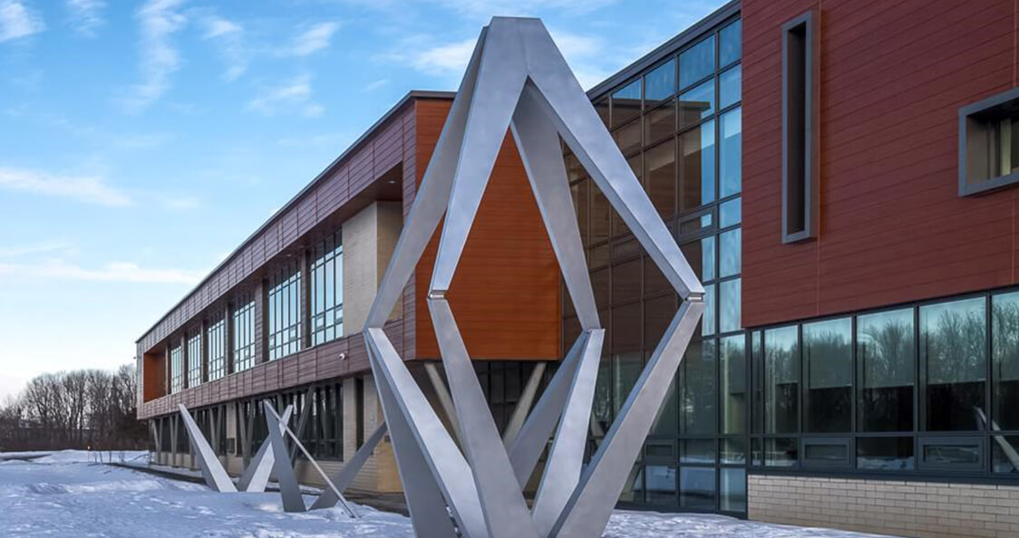 École secondaire moderne avec structure en béton, façade vitrée et grand aménagement extérieur paysager
