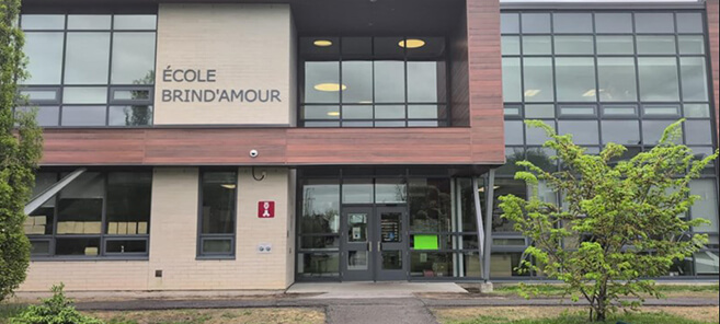 École secondaire construite en béton avec façade vitrée et aménagement extérieur paysager