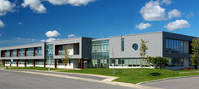 Bâtiment moderne en verre sur un circuit automobile, écuries et voitures de course en action