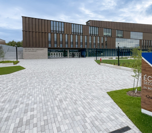 École secondaire du Bosquet, bâtiment institutionnel en béton avec aménagement extérieur pavé